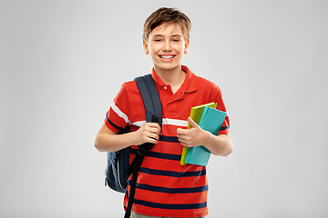 Image showing smiling student boy with backpack and books