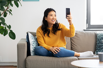 Image showing asian woman taking selfie with smartphone at home