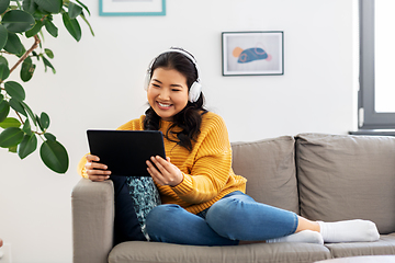 Image showing asian woman with headphones and tablet pc at home