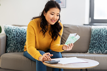 Image showing woman with money, papers and calculator at home