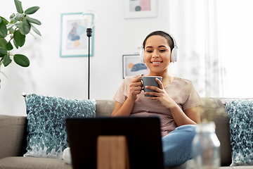 Image showing woman with tablet pc drinking coffee at home