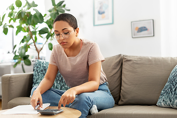 Image showing african woman with papers and calculator at home