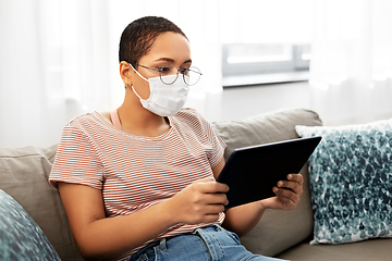 Image showing woman in medical mask with tablet pc at home