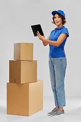 Image showing delivery girl with parcel boxes and tablet pc