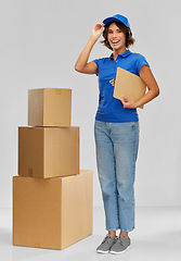 Image showing happy delivery girl with boxes and clipboard