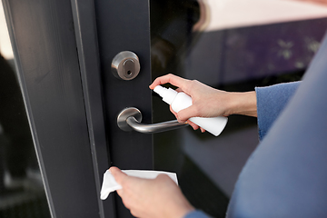 Image showing hand cleaning door handle with disinfectant spray