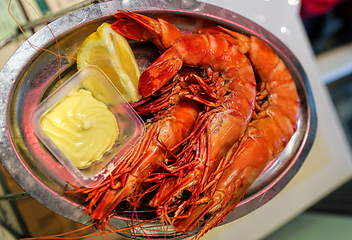 Image showing Jumbo shrimps with lemon and sauce on metal plate 