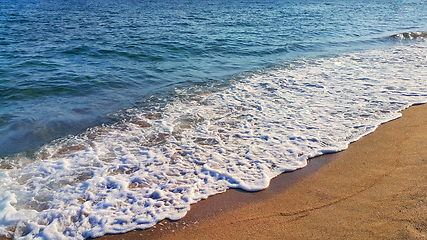 Image showing Sea wave with white foam on the coastal sand