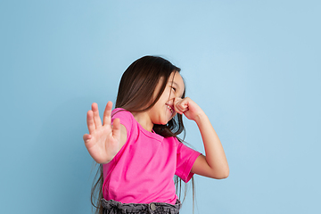 Image showing Caucasian little girl\'s portrait on blue studio background