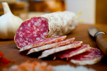 Image showing traditional Italian salame cured sausage sliced on a wood board