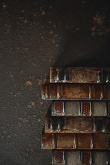 Image showing Old fashioned flat lay with stack of antique leather bound books against a dark background