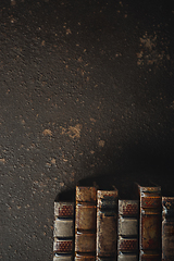 Image showing Old fashioned flat lay with stack of antique leather bound books against a dark background