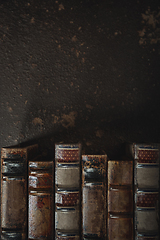 Image showing Old fashioned flat lay with stack of antique leather bound books against a dark background