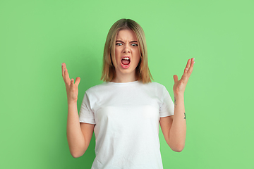 Image showing Caucasian young woman\'s portrait on green studio background