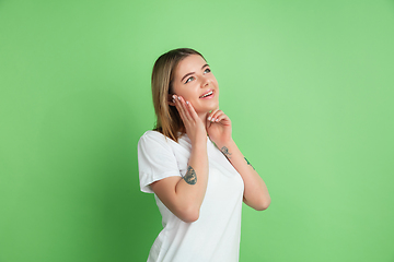 Image showing Caucasian young woman\'s portrait on green studio background