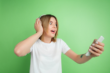 Image showing Caucasian young woman\'s portrait on green studio background