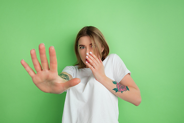 Image showing Caucasian young woman\'s portrait on green studio background