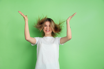 Image showing Caucasian young woman\'s portrait on green studio background