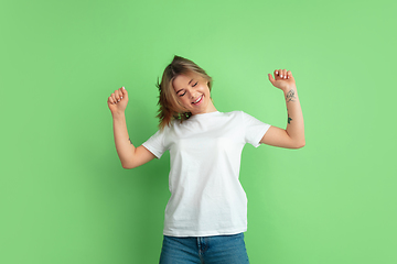 Image showing Caucasian young woman\'s portrait on green studio background