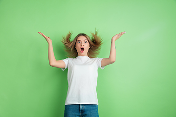 Image showing Caucasian young woman\'s portrait on green studio background