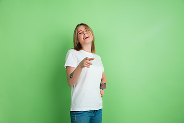 Image showing Caucasian young woman\'s portrait on green studio background