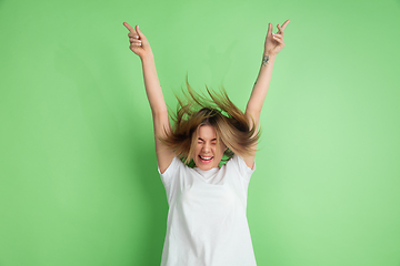 Image showing Caucasian young woman\'s portrait on green studio background