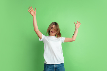 Image showing Caucasian young woman\'s portrait on green studio background