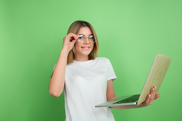 Image showing Caucasian young woman\'s portrait on green studio background