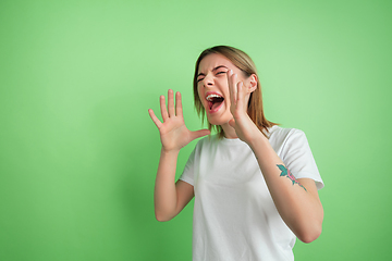 Image showing Caucasian young woman\'s portrait on green studio background