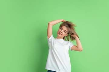 Image showing Caucasian young woman\'s portrait on green studio background