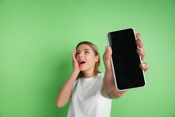 Image showing Caucasian young woman\'s portrait on green studio background