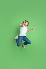 Image showing Caucasian young woman\'s portrait on green studio background