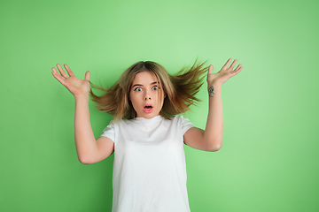 Image showing Caucasian young woman\'s portrait on green studio background