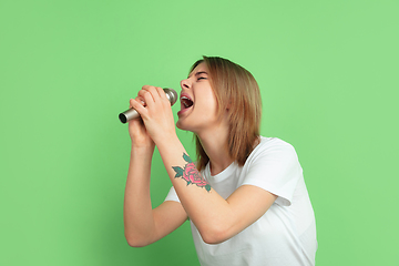 Image showing Caucasian young woman\'s portrait on green studio background