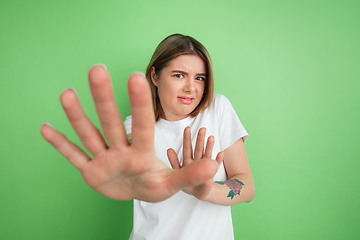 Image showing Caucasian young woman\'s portrait on green studio background