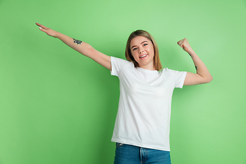 Image showing Caucasian young woman\'s portrait on green studio background