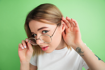 Image showing Caucasian young woman\'s portrait on green studio background