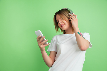 Image showing Caucasian young woman\'s portrait on green studio background