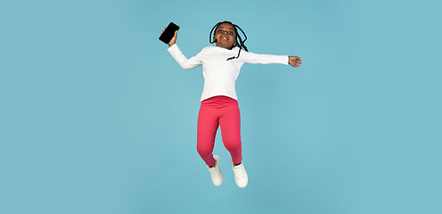 Image showing Handsome african little girl portrait isolated on blue studio background with copyspace