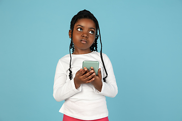 Image showing Handsome african little girl portrait isolated on blue studio background with copyspace