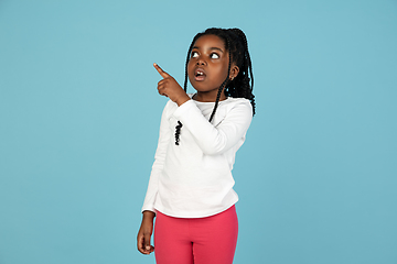 Image showing Handsome african little girl portrait isolated on blue studio background with copyspace