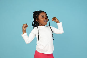 Image showing Handsome african little girl portrait isolated on blue studio background with copyspace