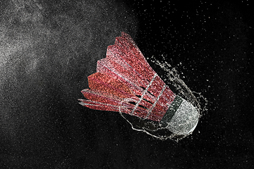 Image showing Shuttlecock in water drops and splashes isolated on black background
