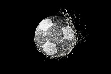 Image showing Football, soccer ball flying in water drops and splashes isolated on black background
