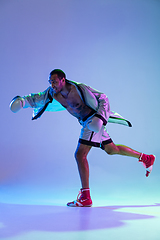 Image showing High-fashion styled man in white outfit pacticing box isolted over gradient background in neon light
