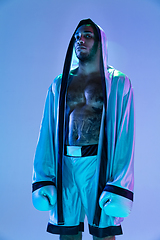 Image showing High-fashion styled man in white outfit pacticing box isolted over gradient background in neon light