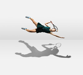 Image showing Young caucasian professional sportswoman levitating, flying while playing tennis isolated on white background