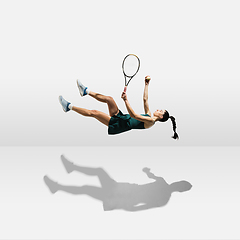 Image showing Young caucasian professional sportswoman levitating, flying while playing tennis isolated on white background