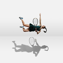 Image showing Young caucasian professional sportswoman levitating, flying while playing tennis isolated on white background