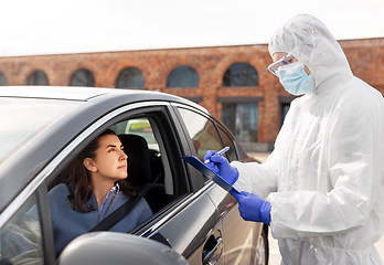 Image showing healthcare worker with clipboard and woman in car